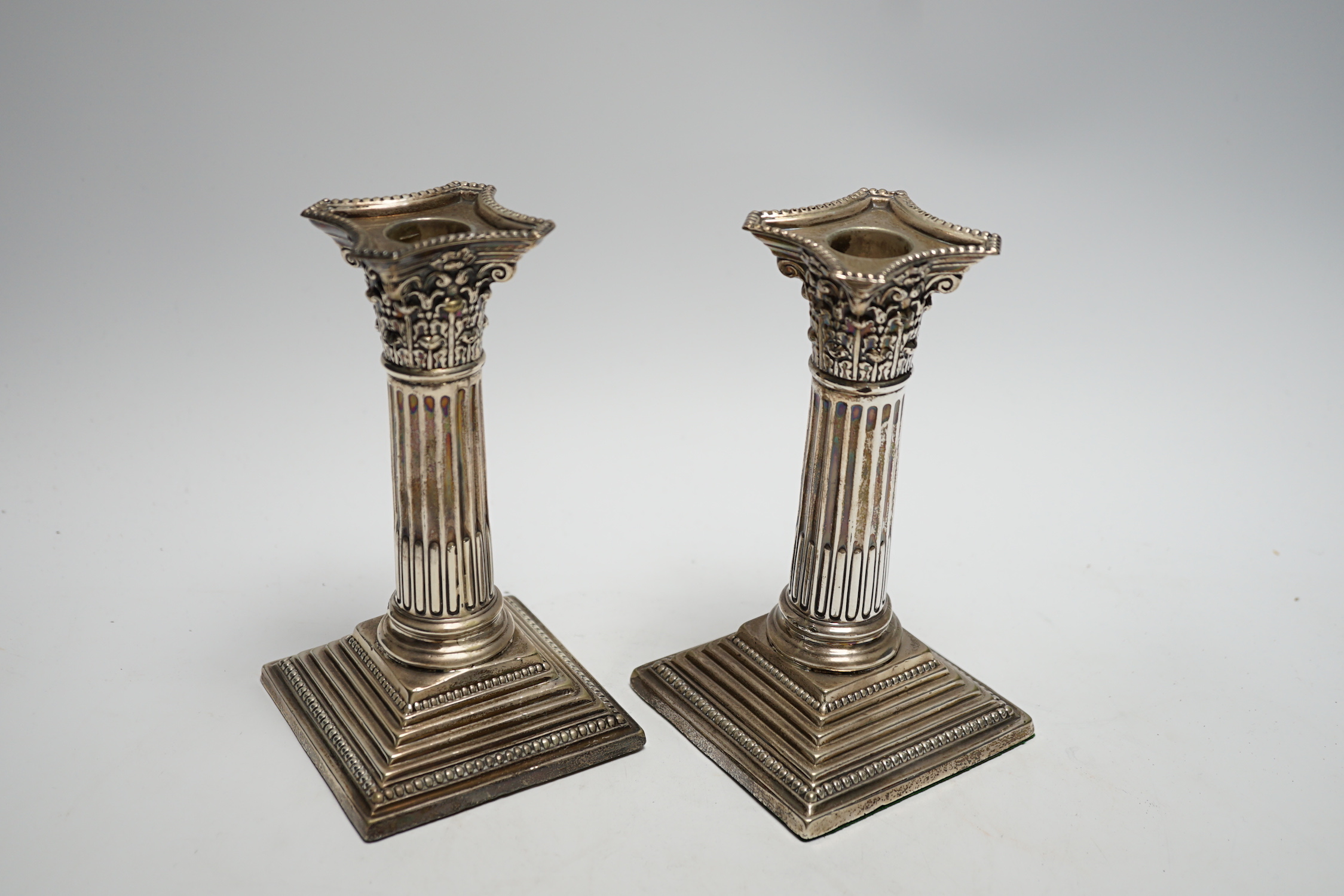 A pair of George V silver mounted Corinthian column dwarf candlesticks, London, 1911, 15.7cm, weighted.